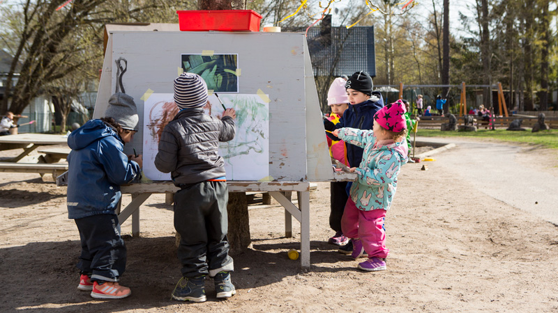 Barn målar utomhus.